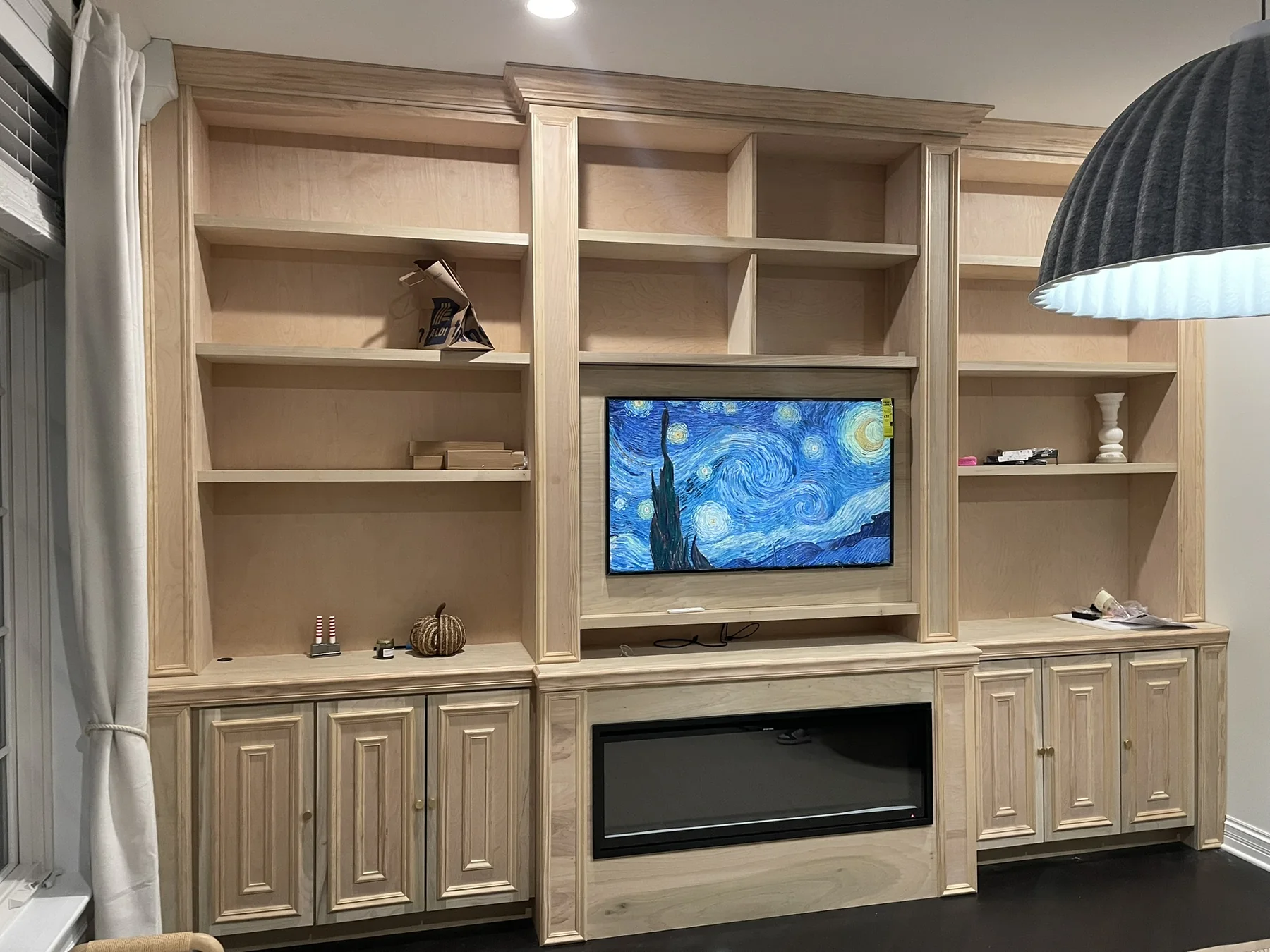 Floor-to-ceiling natural wood entertainment center and cabinetry