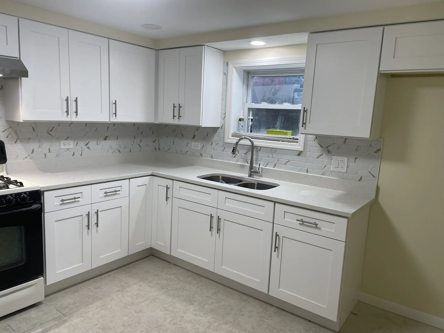 Finished white kitchen with custom cabinetry and stone counters