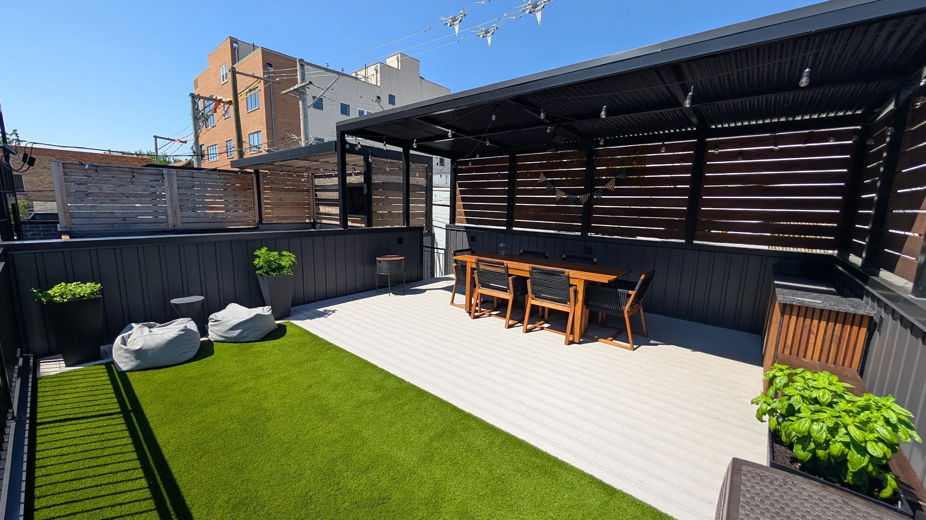 Finished Chicago roof deck with a covered dining area and artificial turf